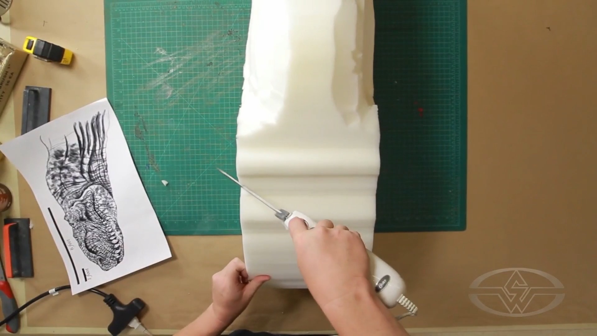 Before Ted Haines carves the head, he references his design.