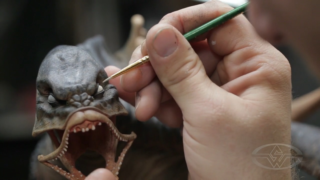 Timothy Martin adds another layer of paint to the whites of the aquatic monster's eyes.