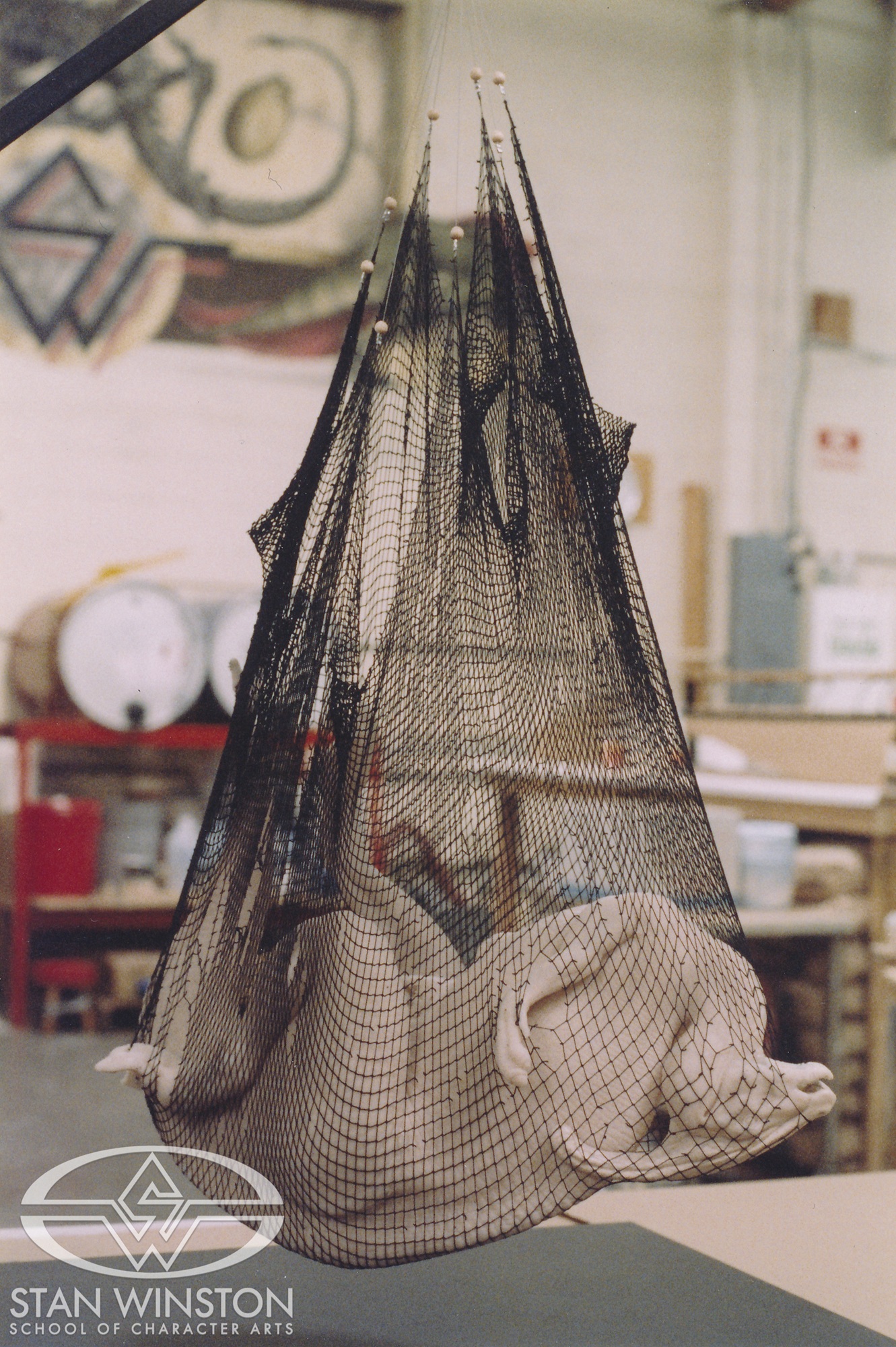 The miniature version of the dead Parasaurolophus in a fishing net at Stan Winston Studio.