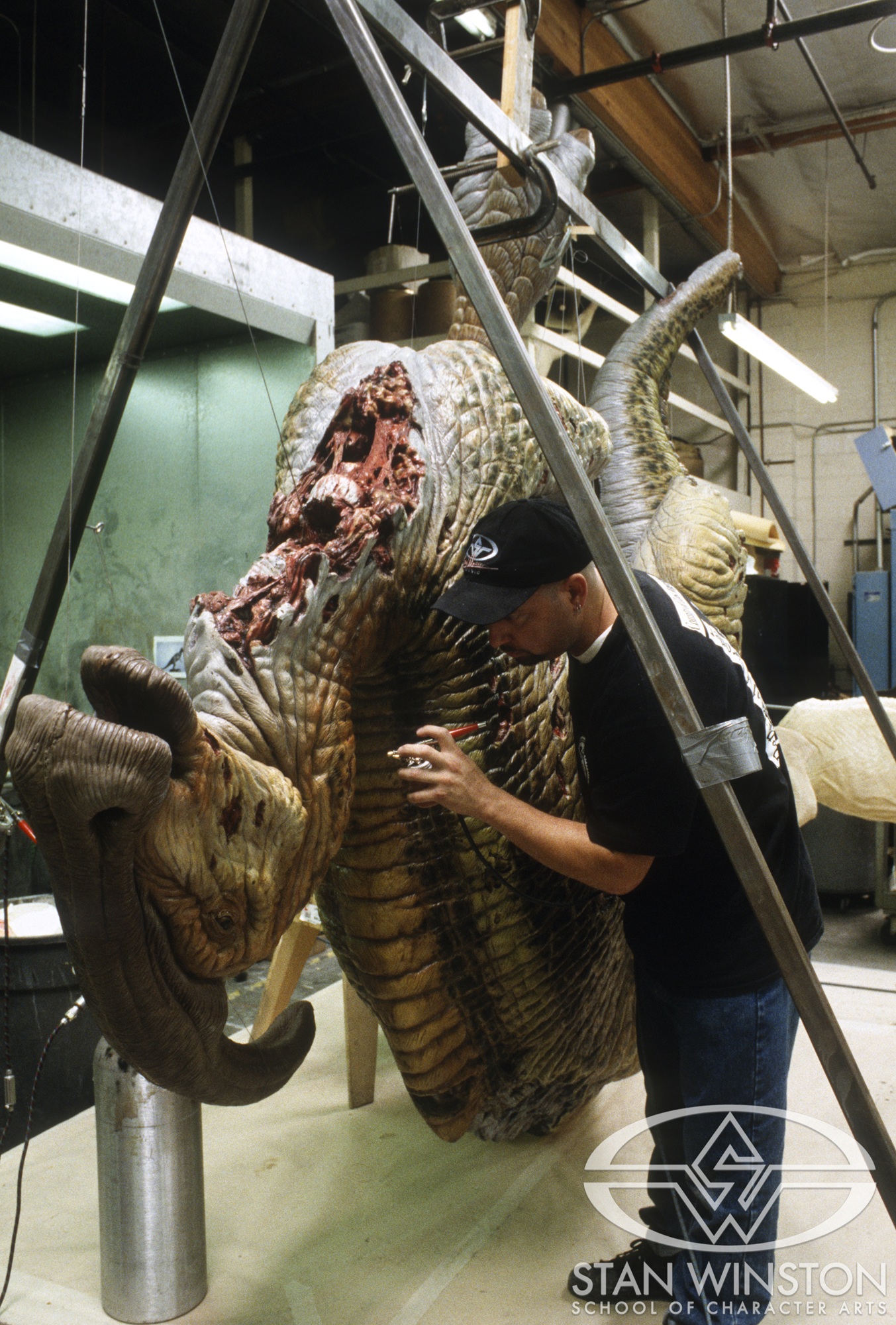 Tim Gore paints the life-size dead Parasaurolophus at Stan Winston Studio.