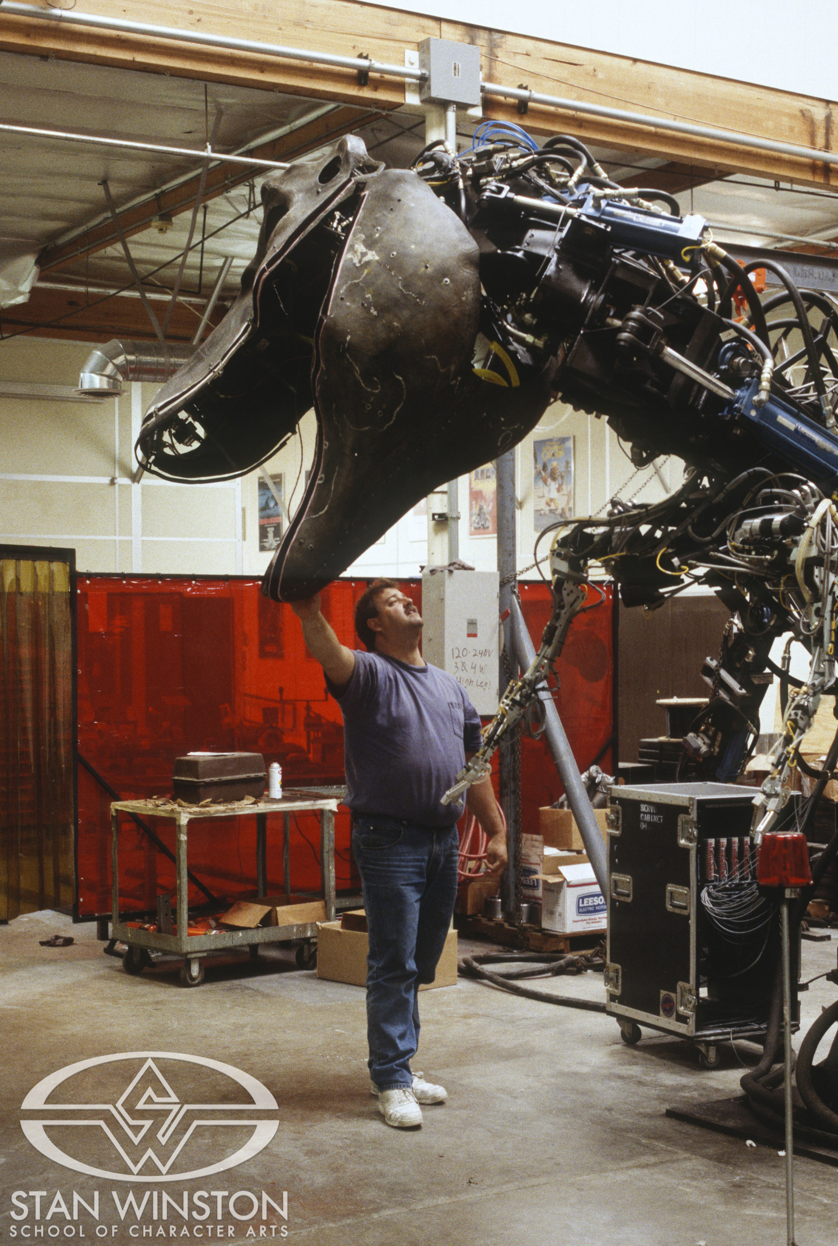 Tim Nordella checks the animatronics of the male T-Rex at Stan Winston Studio.