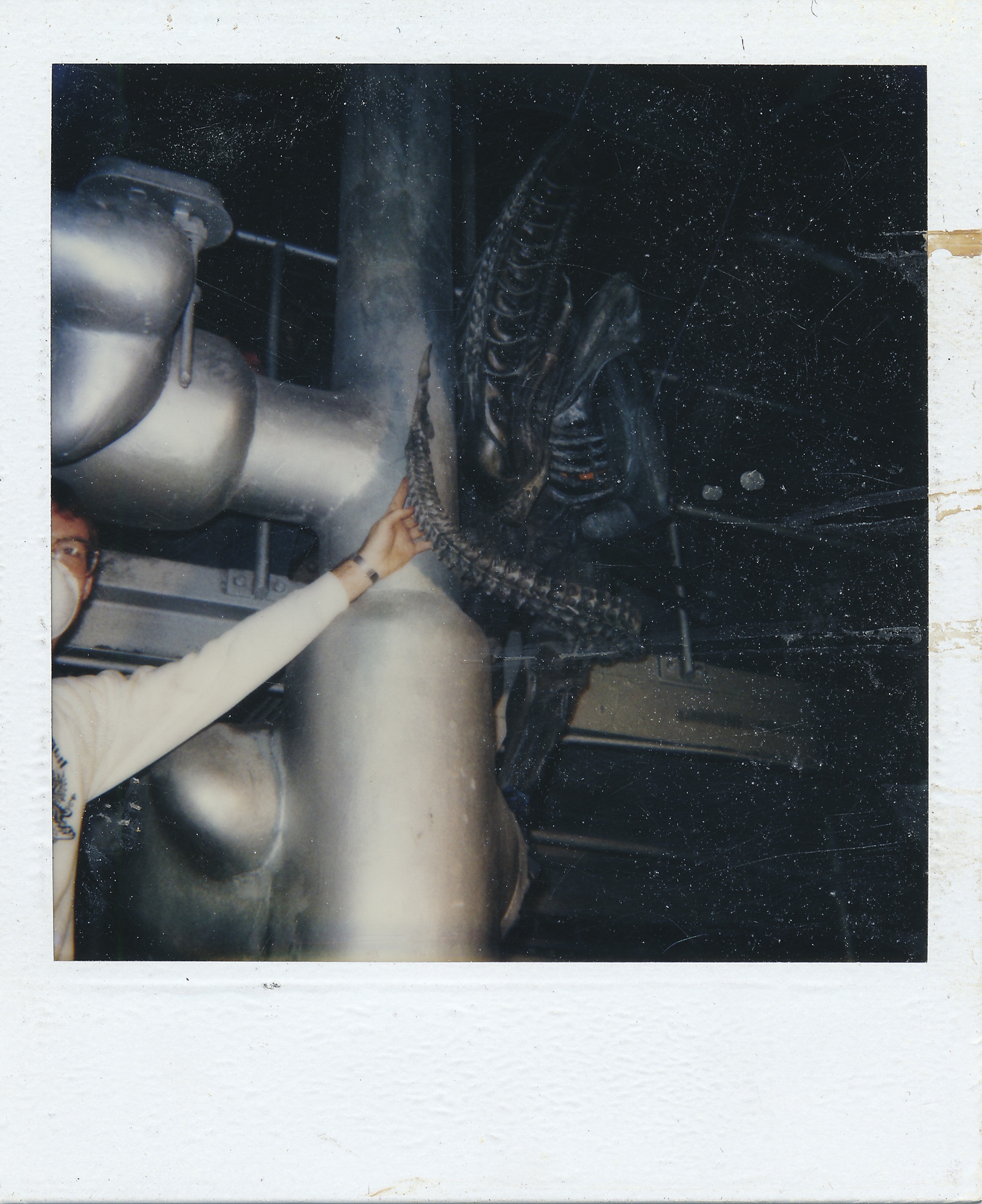 Richard Landon shows the alien tail while a stunt performer in the alien suit positions himself for a shot on the set of Aliens (1986).&nbsp;Image courtesy of&nbsp;20th Century Fox.