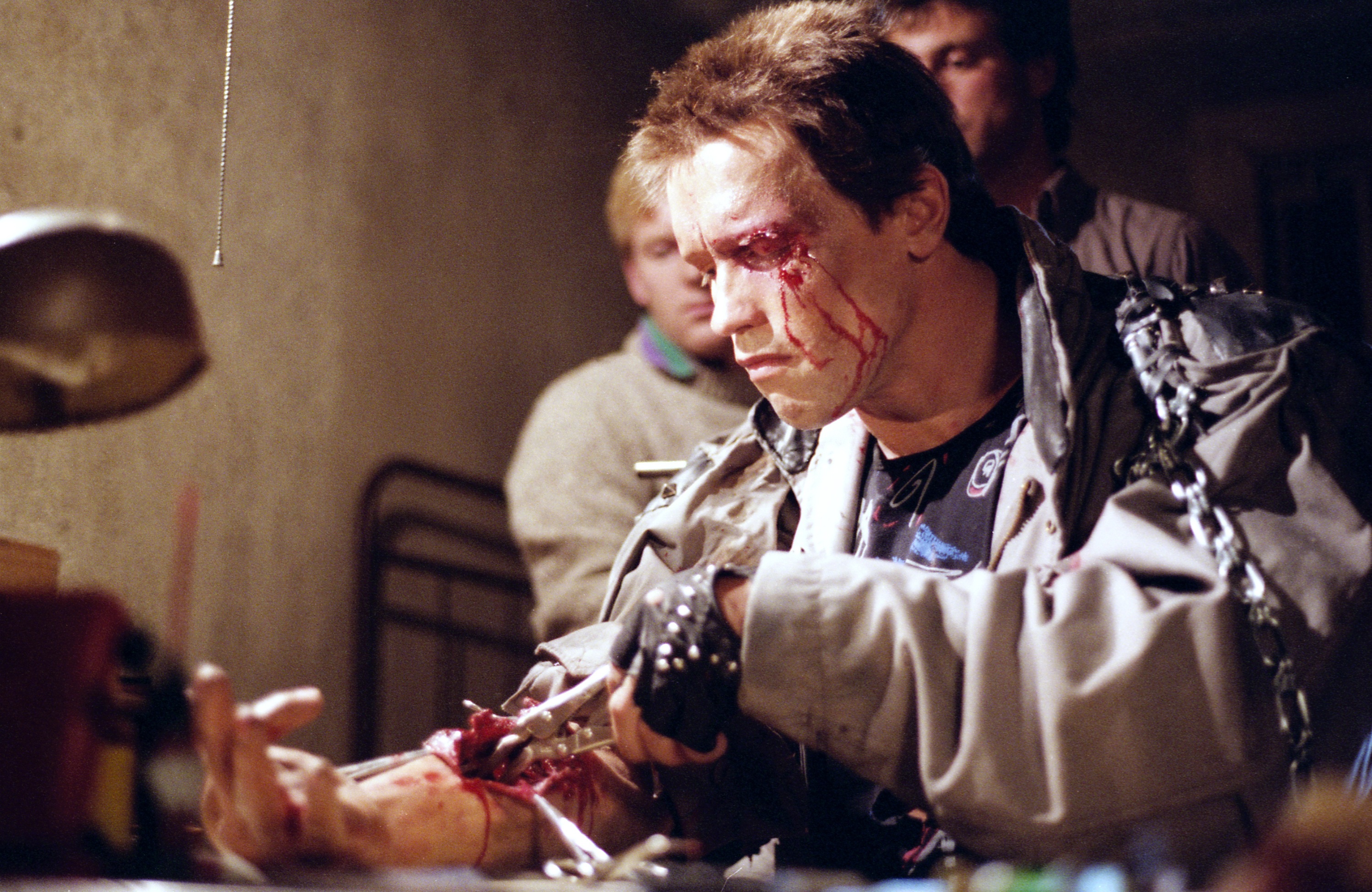 Shane Mahan and John Rosengrant overseeing&nbsp;Arnold Schwarzenegger practicing the arm surgery on the puppet arm.&nbsp;Image courtesy of Hemdale Film, Pacific Western Productions, Euro Film Funding, and Cinema '84.