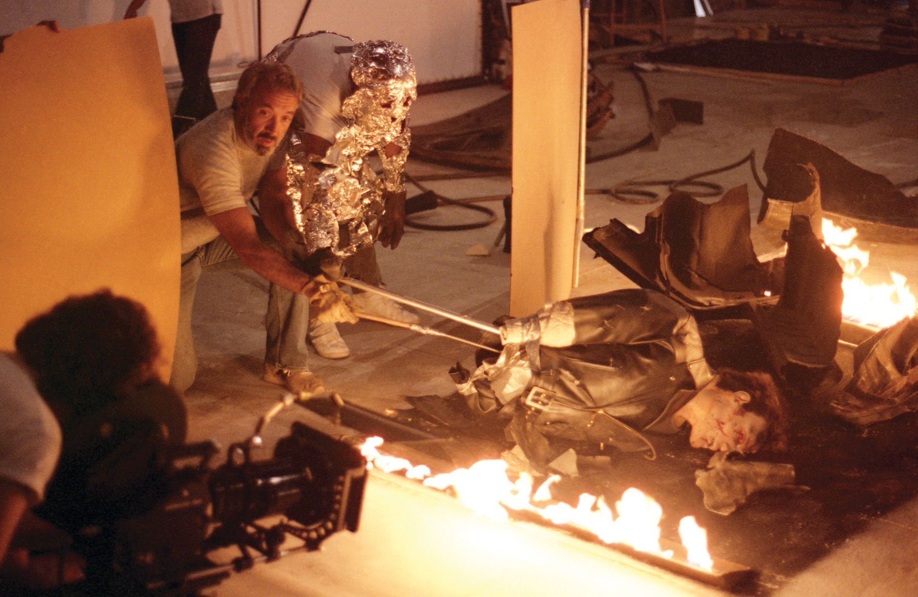 Stan Winston and John Rosengrant — with aluminum foil heat protection — operate a Terminator puppet used specifically for a&nbsp;shot of the cyborg’s flesh burning away in the tanker truck fire. The foam rubber exterior burned away in the real flames, while the plaster underskull representing the endoskeleton remained intact. Image courtesy of Hemdale Film, Pacific Western Productions, Euro Film Funding, and Cinema '84.