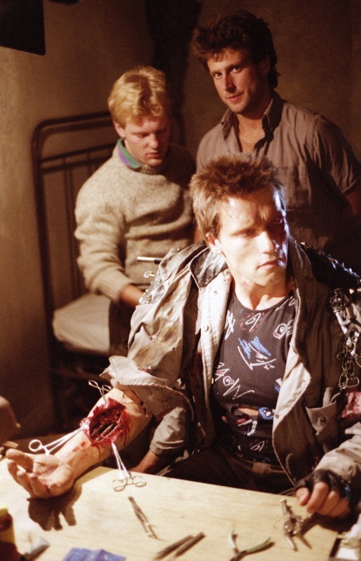 Shane Mahan and John Rosengrant on set with&nbsp;Arnold Schwarzenegger ready for shooting the arm surgery scene.&nbsp;Image courtesy of Hemdale Film, Pacific Western Productions, Euro Film Funding, and Cinema '84.